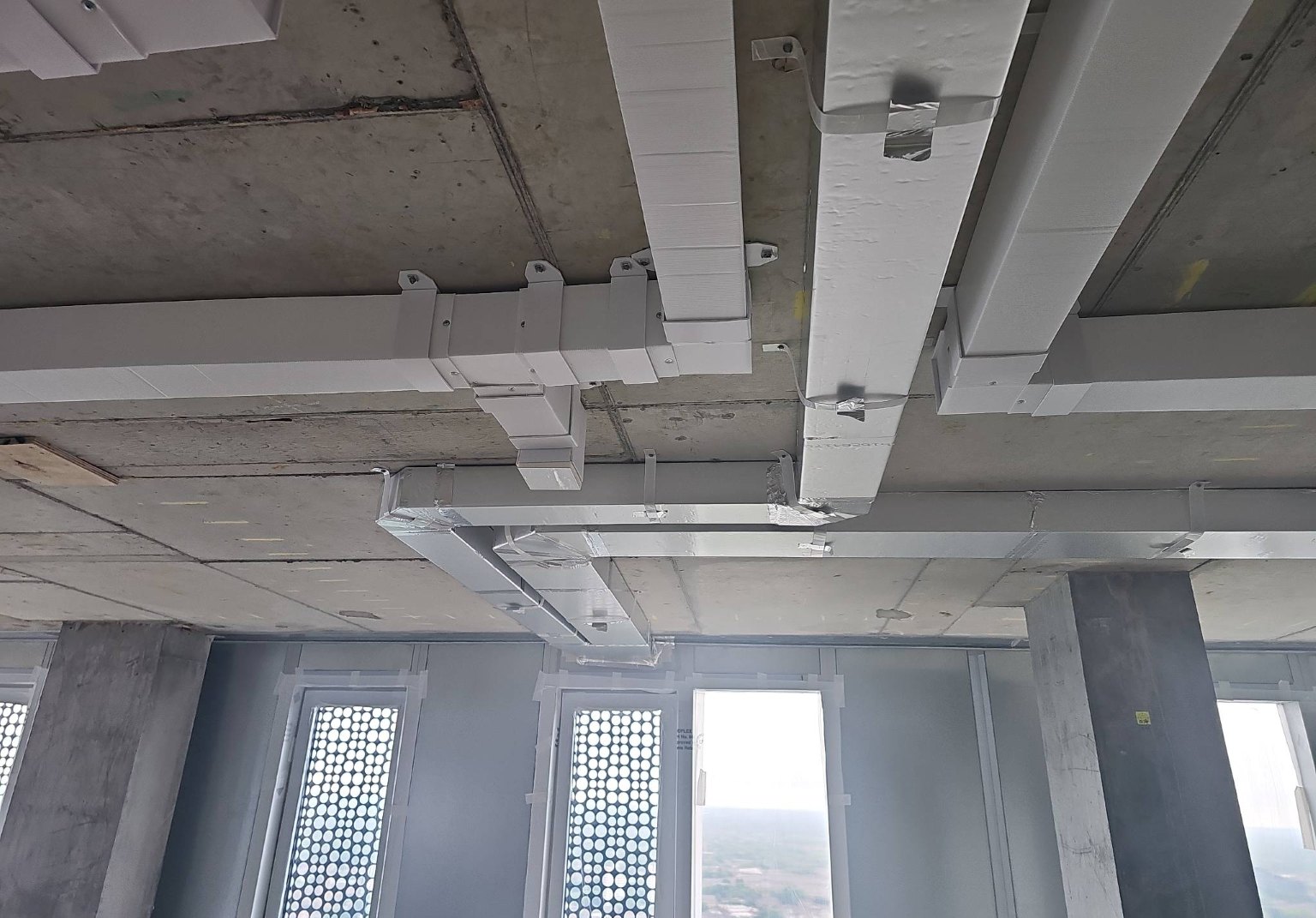 Plastic ventilation ductwork installed on site.