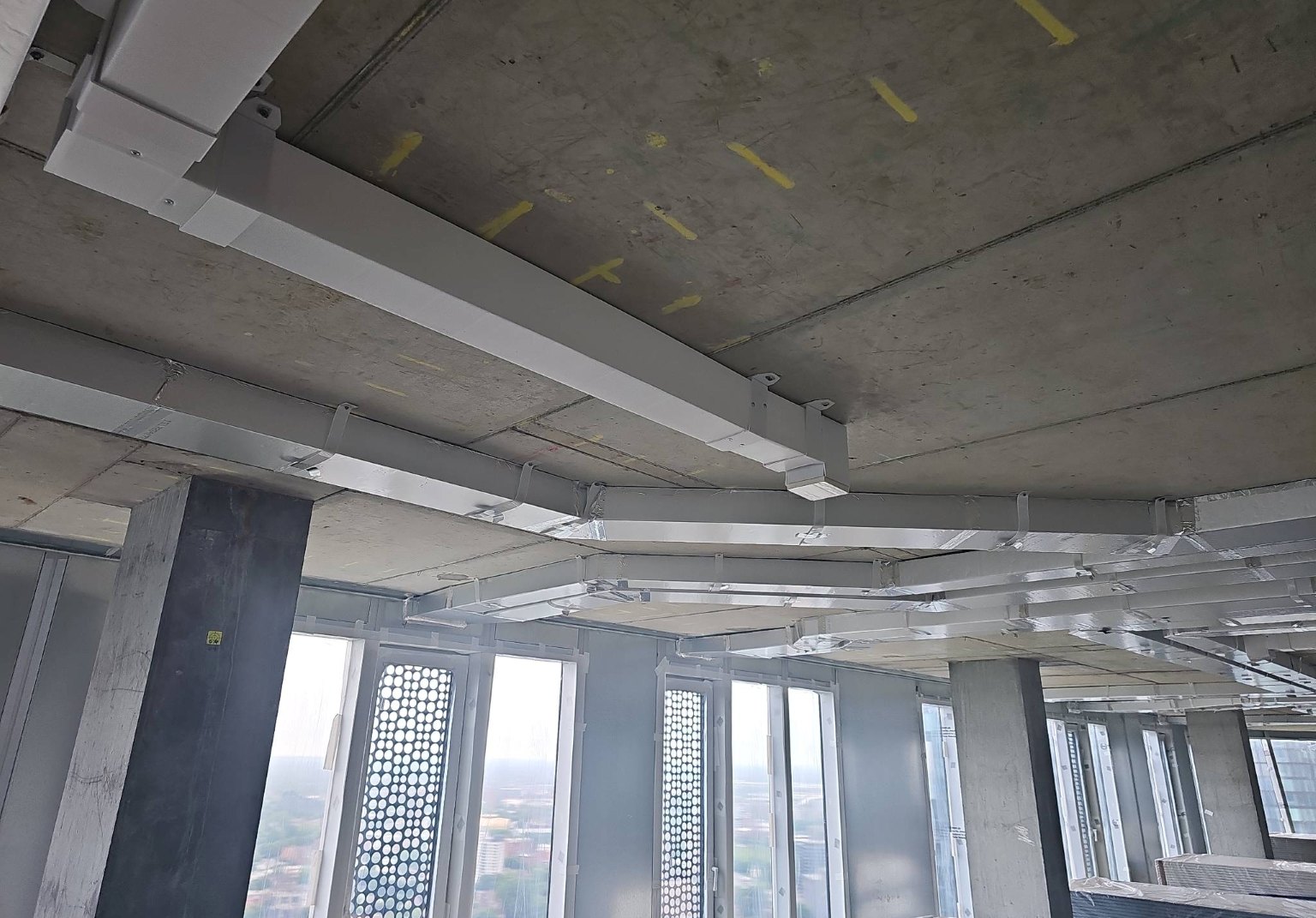 Plastic and insulated ventilation ductwork installed on an apartment construction site